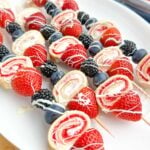 4th of july fruit kabobs on a white plate.