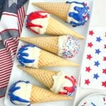ice cream cone cake pops lying on their sides on a white platter.