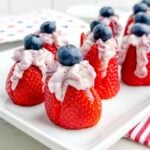 stuffed strawberry cheesecake bites on a white plate.