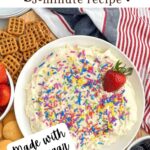 sugar cookie dip in a white bowl with pretzels, fruit, and cookies.