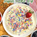 sugar cookie dip in a white bowl with pretzels, fruit, and cookies.