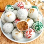 biscoff truffles on a white plate with one on top with a bite taken out.