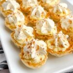 mini coconut cream pies on a white platter.