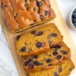 pumpkin blueberry bread on a wooden cutting board.