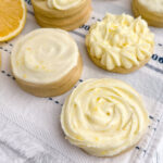 cut out cookies decorated with lemon cream cheese icing.