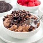 3 ingredient chocolate mousse in a white bowl topped with Oreos, chocolate chips, and chocolate shavings.