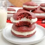 stack of two red velvet whoopie pies on a white plate.