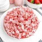 strawberry popcorn drizzled with strawberry white chocolate in a white bowl.
