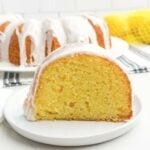 piece of glazed lemon bundt cake on a white plate.