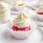 whipped cream cheese frosting on a piece of strawberry cake.