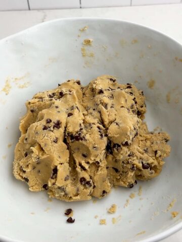 chocolate chip cookie dough in a white bowl.