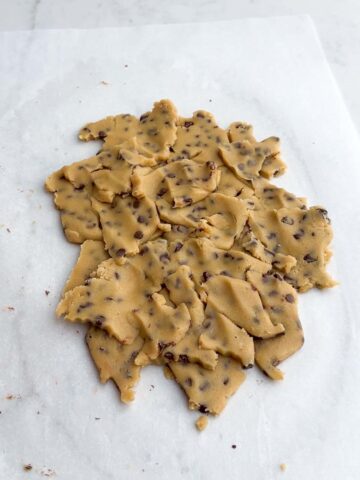 pieces of chocolate chip cookie dough on parchment paper.