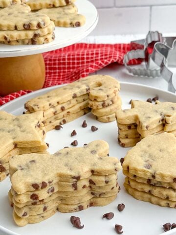 chocolate chip cutout cookies on a white plate and pedestal platter.