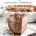 front view of a piece of chocolate mousse pie topped with chocolate whipped cream with a bite taken out.