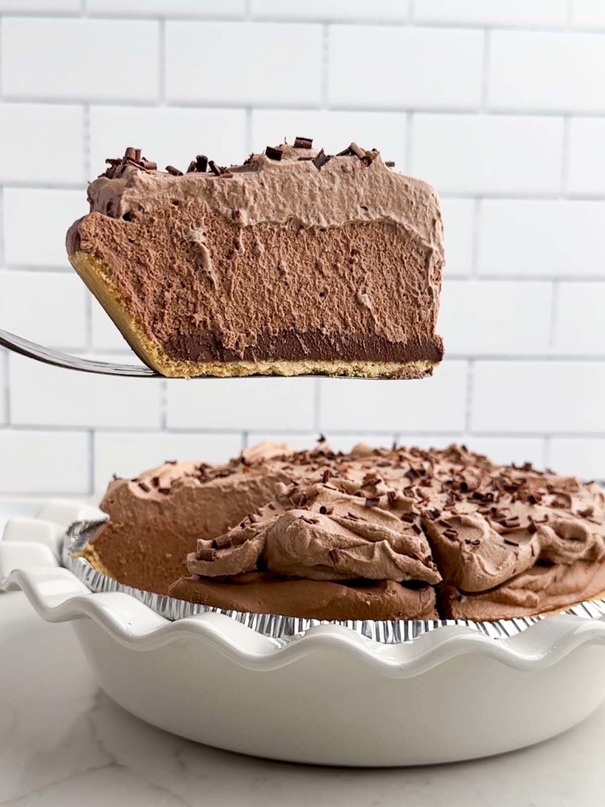 pie server lifting a piece of chocolate mousse pie over the rest of the pie.