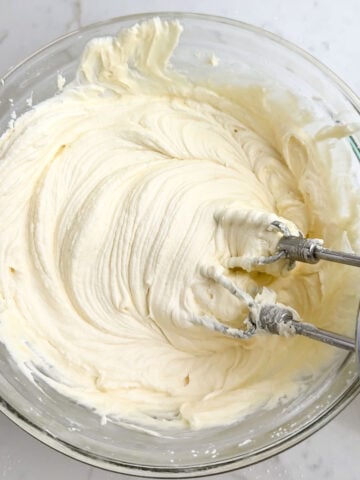 cream cheese frosting in a clear mixing bowl.