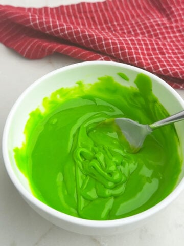 green tinted gingerbread icing in a white bowl.
