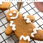 hand piping icing onto a gingerbread man.