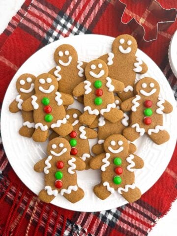 gingerbread men with white icing on a white plate.