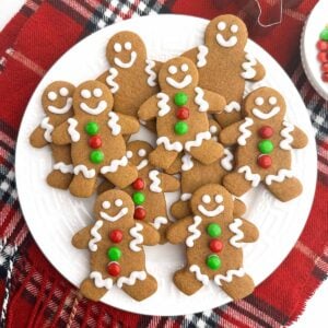 gingerbread men with white icing on a white plate.