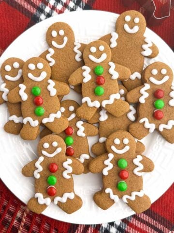 gingerbread men with white icing on a white plate.