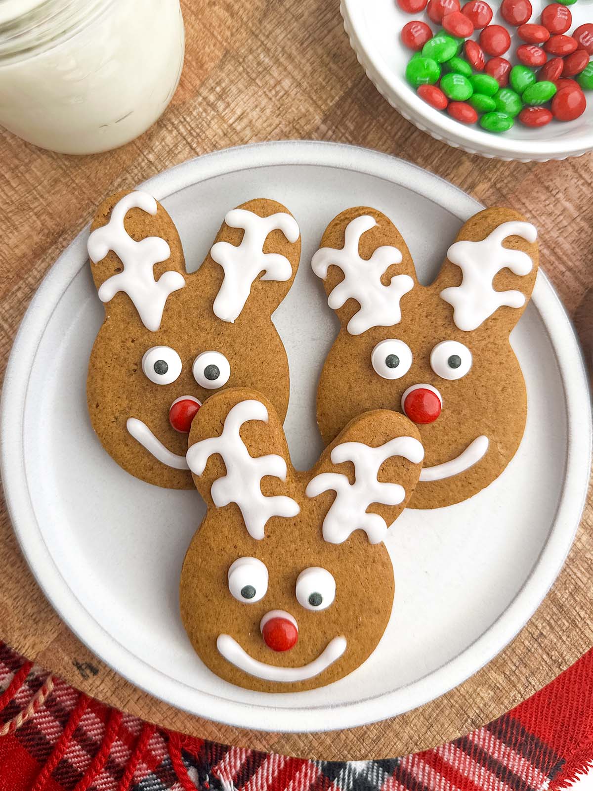 gingerbread reindeer with white icing on a white plate.