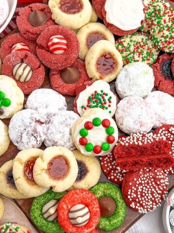 variety of cake mix christmas cookies on a wooden cutting board.
