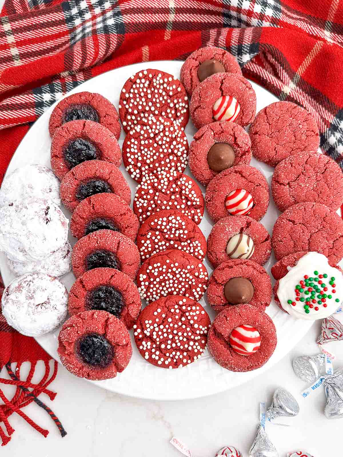variety of red velvet cake mix christmas cookies on a wooden cutting board.