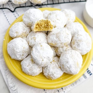 lemon snowball cookies on a yellow plate.